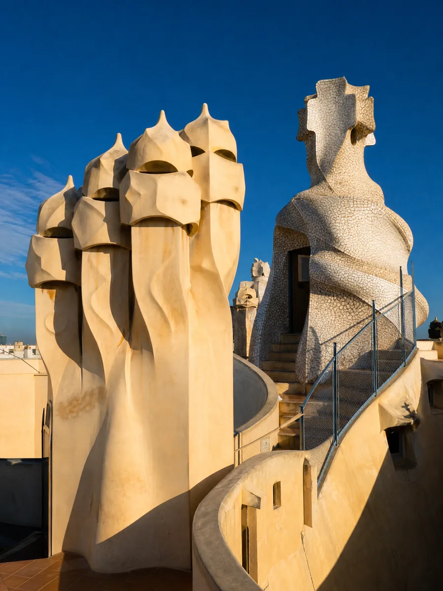 Verdrehte cremefarbene Dachschornsteine in Form von helmbedeckten Figuren vor einem tiefblauen Himmel